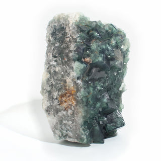 Fluorite Cluster Unique #54 standing upright, showing the pale grey quartz matrix side with rust-orange iron staining beside the green fluorite cubes, photographed on a clean white background. Stonebridge Imports.