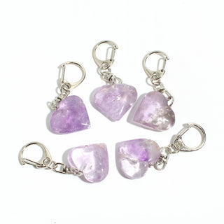 Amethyst Heart Charm - Pack of 5 - five polished pale lilac amethyst hearts, each on its own silver-tone swivel clasp, arranged on a clean white background. Stonebridge Imports.