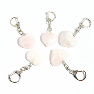 Rose Quartz Heart Charm - Pack of 5 - five polished soft pink rose quartz hearts, each on its own silver-tone swivel clasp, arranged on a clean white background. Stonebridge Imports.