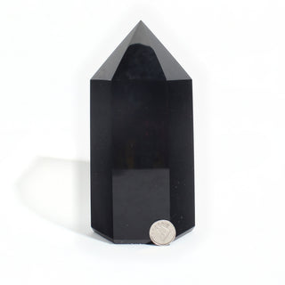 Black Obsidian Generator Unique #5 — polished six-sided tower with a faceted point, beside a Canadian dime for scale, photographed on a clean white background. Stonebridge Imports.
