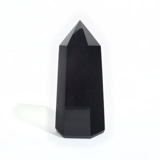 Black Obsidian Generator Unique #6 — polished six-sided tower rising to a faceted point, glossy jet-black faces, photographed on a clean white background. Stonebridge Imports.