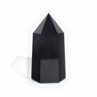 Black Obsidian Generator Unique #7 — polished six-sided tower rising to a faceted point, glossy jet-black faces, photographed on a clean white background. Stonebridge Imports.