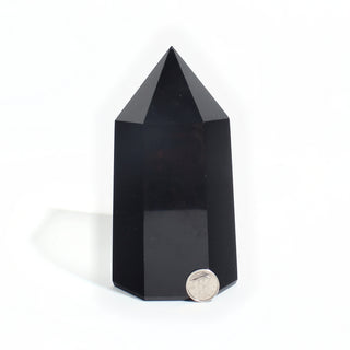 Black Obsidian Generator Unique #7 — polished six-sided tower with a faceted point, beside a Canadian dime for scale, photographed on a clean white background. Stonebridge Imports.