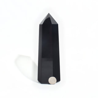 Black Obsidian Generator Unique #9 — polished six-sided tower with a faceted point, beside a Canadian dime for scale, photographed on a clean white background. Stonebridge Imports.
