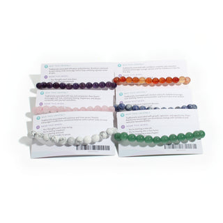 Card backs showing the Why this crystal and Wear this when text and a till barcode on each intention bracelet card, on white. Stonebridge Imports.