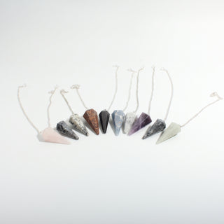 Mixed Stone Pendulums 10-Pack, ten six-sided faceted stone pendulums on silver chains shown at a three-quarter angle on a clean white background. Stonebridge Imports.