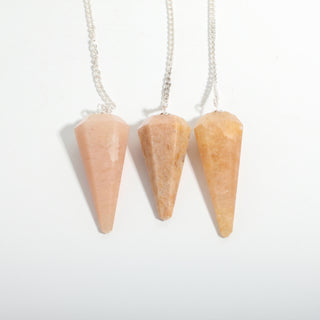 Peach Aventurine Pendulum 6 Facet & Bead - 3 Pack, three peach aventurine pendulums hanging side by side on a clean white background. Stonebridge Imports.