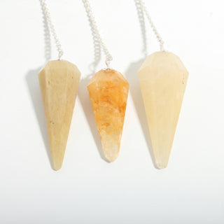 Golden Quartz Pendulum 6 Facet & Bead - 3 Pack, three yellow to amber golden quartz pendulums hanging side by side on a clean white background. Stonebridge Imports.