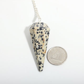 Dalmatian Jasper Pendulum 6 Facet & Bead - 3 Pack, one spotted Dalmatian jasper pendulum beside a dime for scale, on a clean white background. Stonebridge Imports.