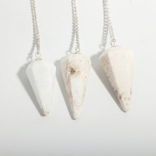 Scolecite Pendulum 6 Facet & Bead - 3 Pack, three milky white scolecite pendulums hanging side by side on a clean white background. Stonebridge Imports.