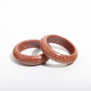 Brown Goldstone Ring (Enhanced) — solid brown goldstone with copper sparkle stone band ring, photographed on a clean white background. Stonebridge Imports.