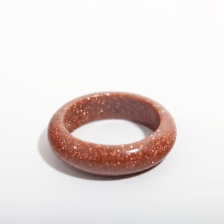 Brown Goldstone Ring (Enhanced) — solid brown goldstone with copper sparkle stone band ring, alternate angle photographed on a clean white background. Stonebridge Imports.