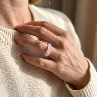 Rose Quartz Ring worn on the hand in natural light, showing the solid pale pink rose quartz band at true scale.