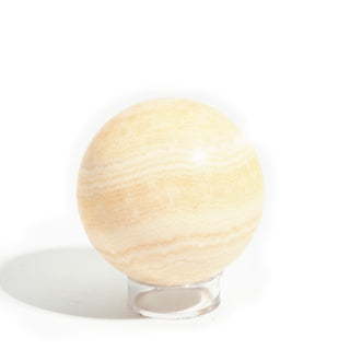 Small #2 - 2 1/4" — Orange Calcite Sphere - Mexico, a pale peach-cream calcite sphere wrapped in soft honey banding, photographed on a clean white background. Stonebridge Imports.