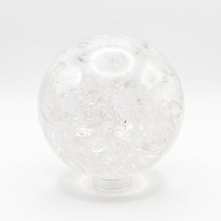 Clear Quartz Sphere Unique #18 - 6 1/4", a polished clear quartz sphere on a clear display stand showing internal veils and rainbow inclusions, photographed on a clean white background. Stonebridge Imports.