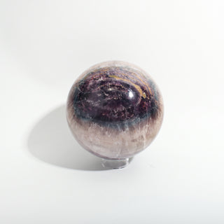 Fluorite Green and Purple Sphere Unique #10, showing deep purple and violet banded fluorite with amber-gold seams, photographed on a clean white background. Stonebridge Imports.