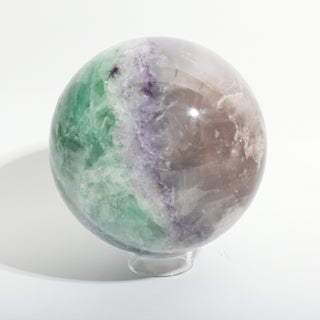 Fluorite Green and Purple Sphere Unique #12, alternate angle showing green and purple fluorite with a golden-brown inclusion, on a clean white background. Stonebridge Imports.