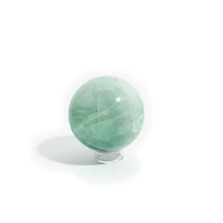 Fluorite Green and Purple Sphere Unique #16 seen from a second side, showing the glassy internal planes and soft white banding inside the mint-green fluorite, photographed on a clean white background. Stonebridge Imports.