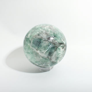 Fluorite Green and Purple Sphere Unique #9, showing translucent sea-green fluorite with white and grey veining, photographed on a clean white background. Stonebridge Imports.