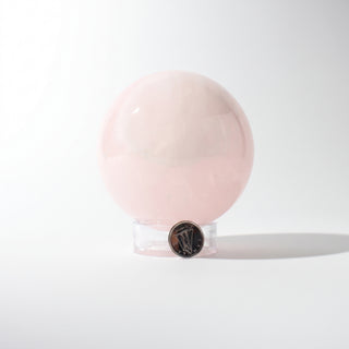 Rose Quartz Sphere Unique #39 - 3 3/8, alternate angle with a dime for scale, photographed on a clean white background. Stonebridge Imports.
