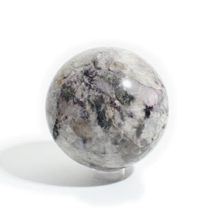 Black Tourmaline and Smoky Quartz Sphere Unique #1, cloudy white and smoky grey quartz patched with black tourmaline, photographed on a clean white background. Stonebridge Imports.