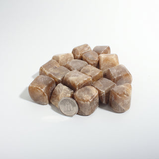 Medium — Honey Calcite Tumbled Stones - India, a pile of honey-brown tumbled calcite beside a Canadian dime for scale, photographed on a clean white background. Stonebridge Imports.