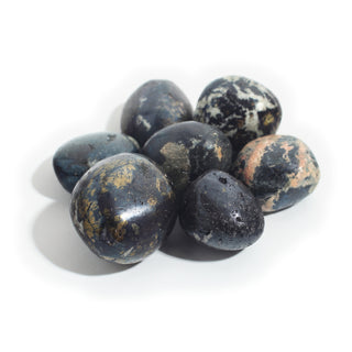 Large — Covellite Tumbled Stones, seven deep indigo-black stones with brassy gold pyrite patches, one with soft pink matrix, photographed on a clean white background. Stonebridge Imports.
