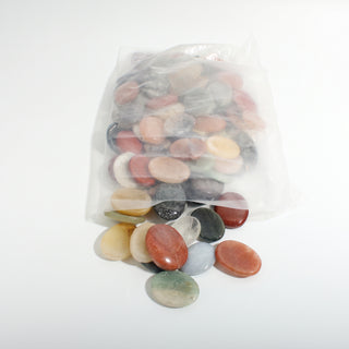 Mixed Stone Worry Stones 100-Pack shown in its resealable bag with colourful oval palm stones spilling out, on a clean white background. Stonebridge Imports.