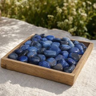 Agate Blue Tumbled Stones (Enhanced) in a wooden tray at a market stall