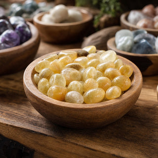 Amber Aragonite Tumbled Stones in a wooden bowl on a boutique display table