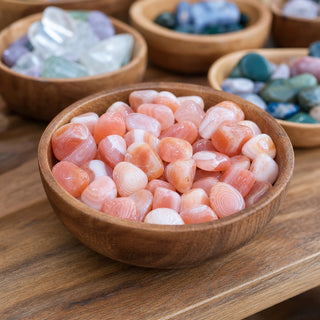 Apricot Agate Tumbled Stones in a wooden bowl on a boutique display table
