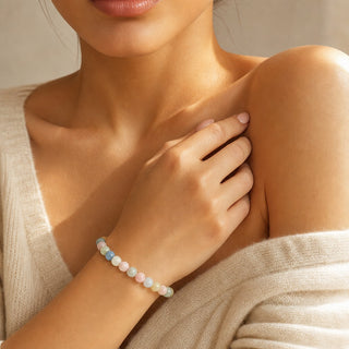 Aquamarine & Morganite bead bracelet worn with the fingertips resting at the collarbone