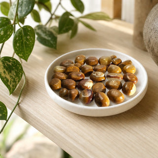 Aragonite Brown Tumbled Stones in a stoneware dish on a shop shelf
