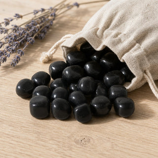 Black Obsidian Tumbled Stones - India spilling from a linen pouch