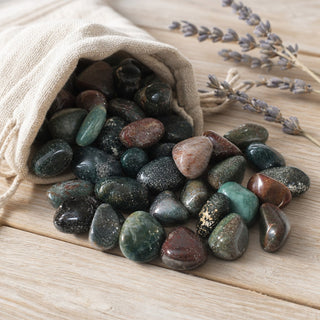 Indian Bloodstone Tumbled Stones spilling from a linen pouch