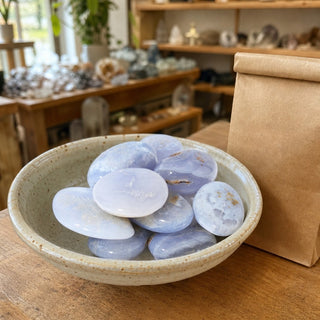 Blue Chalcedony Tumbled Stones in a ceramic bowl on a shop counter