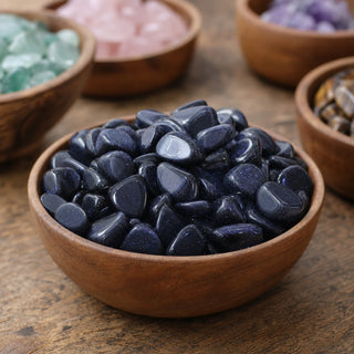 Blue Goldstone Tumbled Stones (Synthetic) in a wooden bowl on a boutique display table