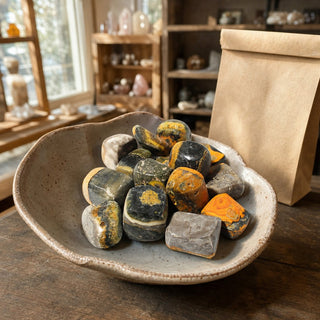 Bumble Bee Jasper Tumbled Stones in a ceramic bowl on a shop counter