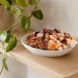 Carnelian E Tumbled Stones - Brazil in a stoneware dish on a shop shelf