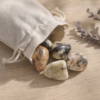 Cassiterite In Quartz Tumbled Stones spilling from a linen pouch