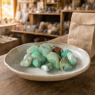 Chrysoprase E Tumbled Stones - Brazil in a ceramic bowl on a shop counter