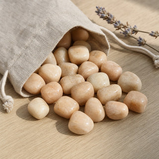 Cream Moonstone Tumbled Stones spilling from a linen pouch