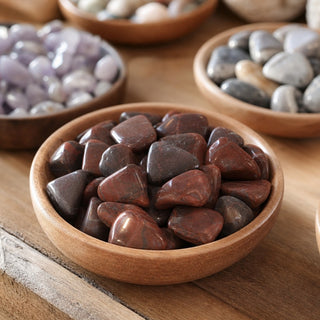 Dolomite Red Tumbled Stones in a wooden bowl on a boutique display table