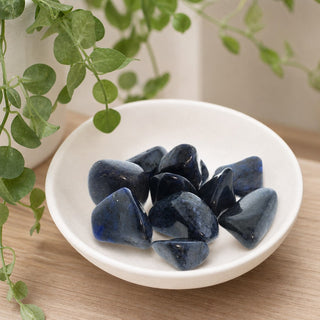 Dumortierite Tumbled Stones in a stoneware dish on a shop shelf