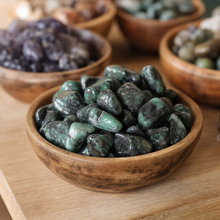 Emerald A Tumbled Stones in a wooden bowl on a boutique display table