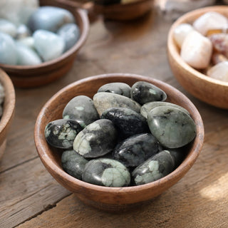 Emerald B Tumbled Stones in a wooden bowl on a boutique display table
