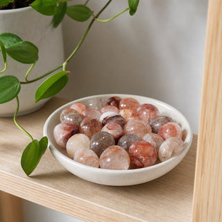 Fire Quartz Tumbled Stones in a stoneware dish on a shop shelf