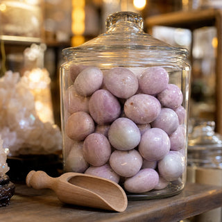 Kunzite Tumbled Stones in a glass apothecary jar with a scoop