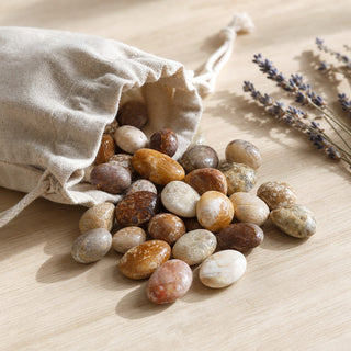 Fossil Jade Tumbled Stones spilling from a linen pouch