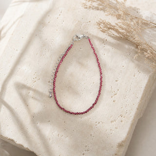 Garnet bead bracelet resting on a stone slab